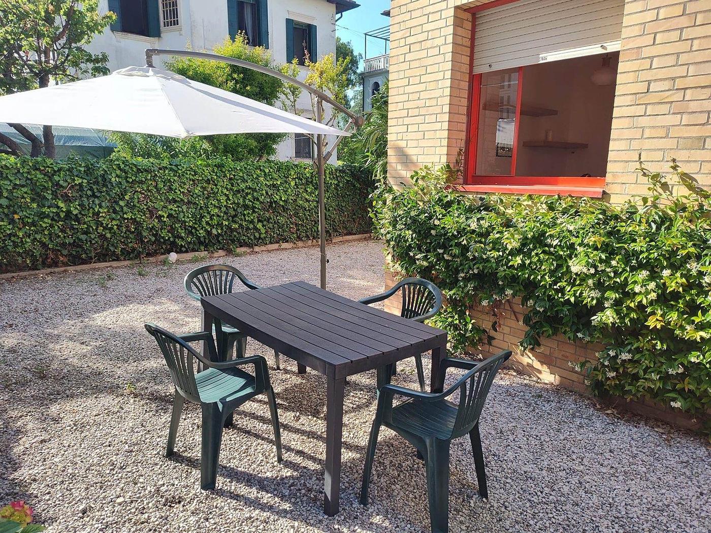 Area pranzo in giardino con tavolo e ombrellone